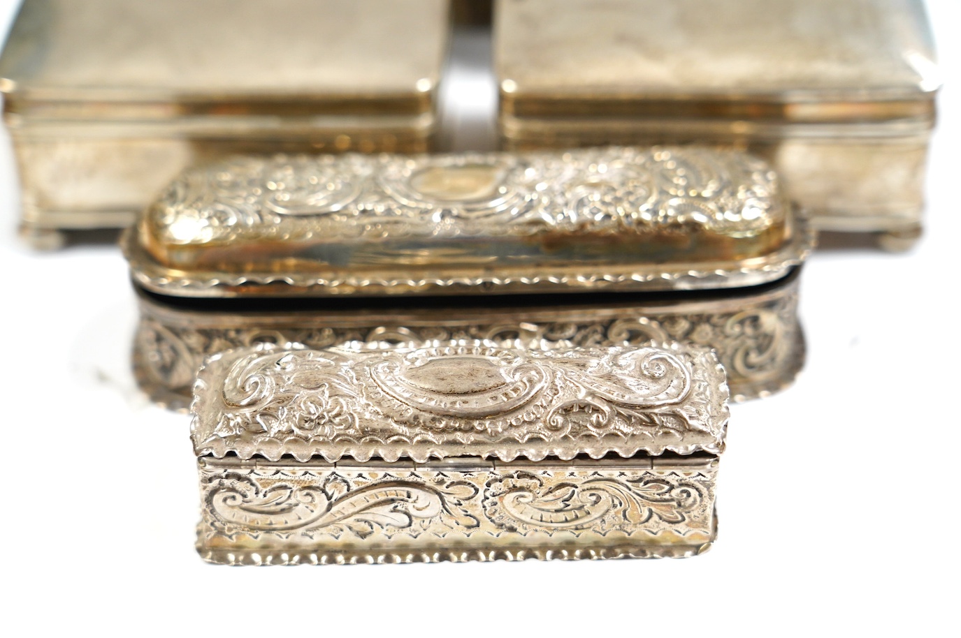 Two late Victorian repousse silver trinket boxes, largest 13.3cm, a pair of George V silver trinket boxes and a tortoiseshell and silver mounted circular trinket box. Condition - poor to fair